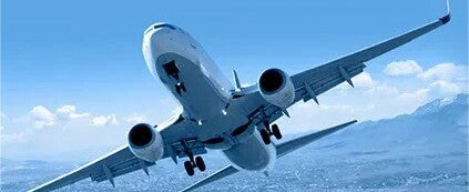 A wide-angle shot of a commercial airplane soaring through a clear blue sky, representing the 2026 airline travel standards for pet parents navigating long-distance transport with large breeds.