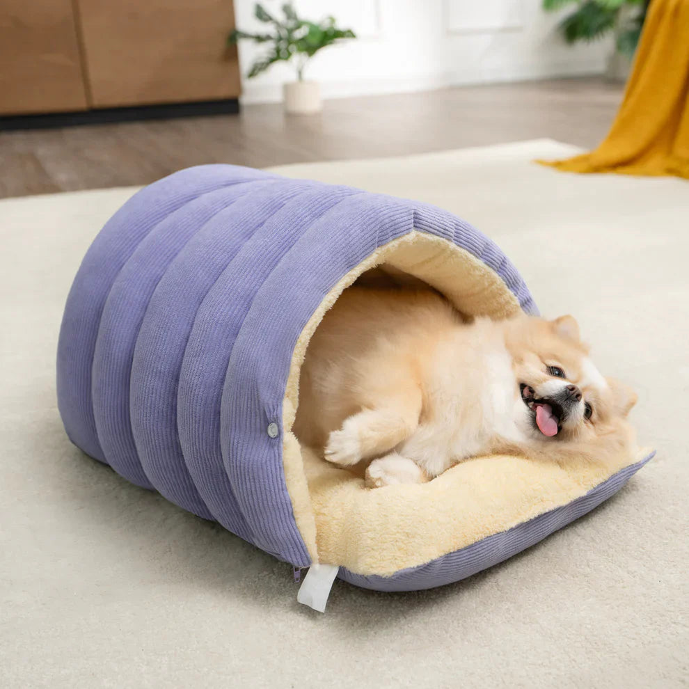 A happy dog enjoying deep sleep inside the purple Dogegis™ anxiety-relief cave bed