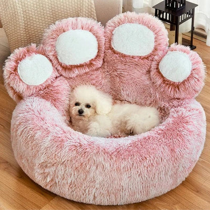 A small dog lounging in a pink paw-shaped Dogegis™ anti-anxiety faux fur pet bed.