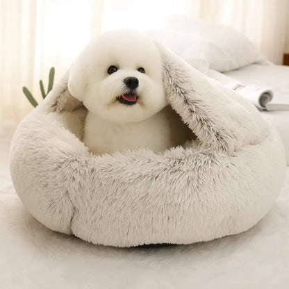 A small puppy resting inside the cream-colored Dogegis® CozyNook hooded dog cave bed